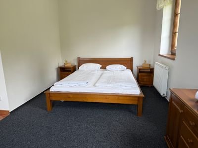 Celkový pohled na apartmán s postelí a kuchyňkou