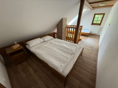 Lůžka v podkroví s dřevěným obložením