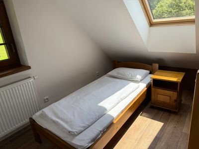 Lůžka v podkroví s dřevěným stropem