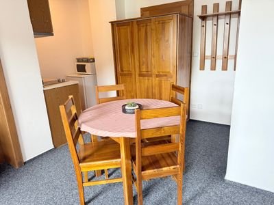 Apartmán 4 — jídelní kout s dřevěným stolem