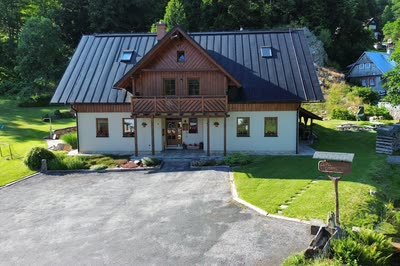 Průčelí horského domu Apartmány Udatný s dřevěným balkonem